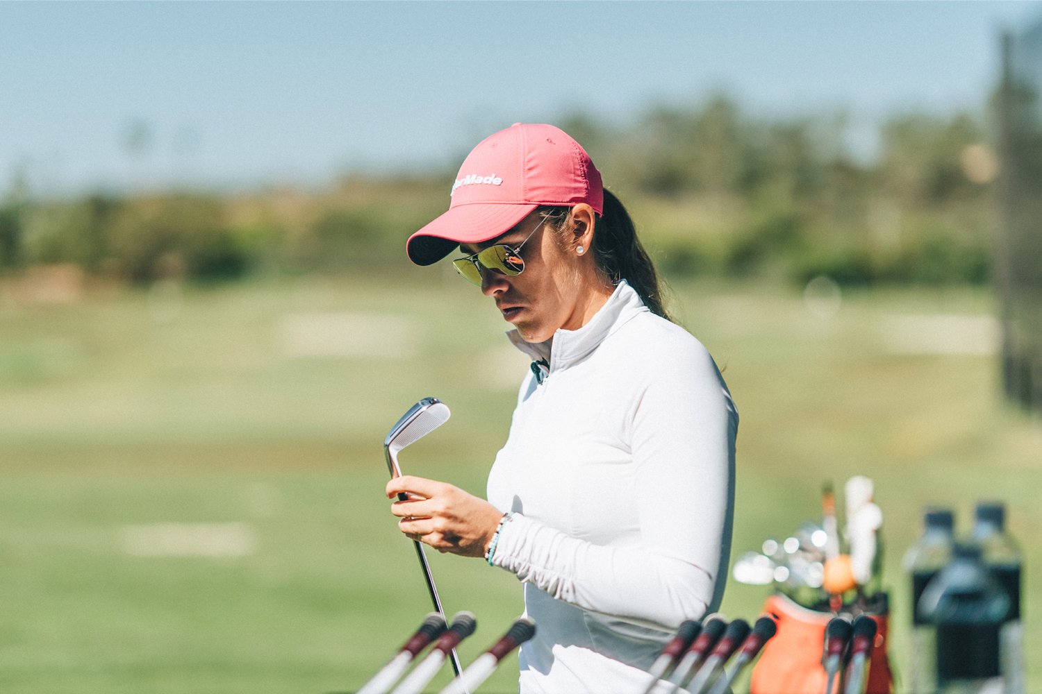 Golfer inspecting irons at TaylorMade's The Kingdom golf fitting facility in Carlsbad