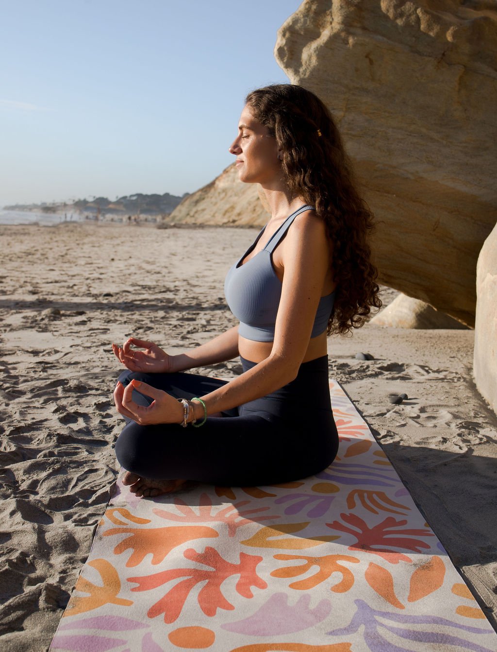 Woman on beach doing yoga on a yoga mat from San Diego brand Rêver Yoga 