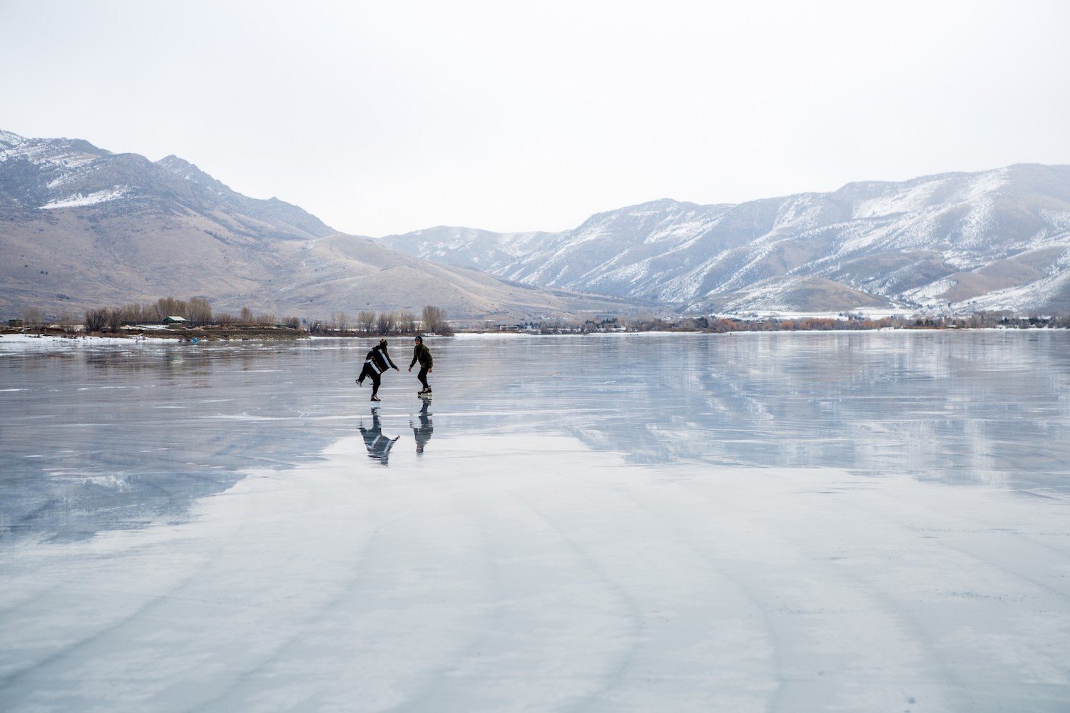 People ice skating at Pineview Reservoir in Huntsville, Utah during winter