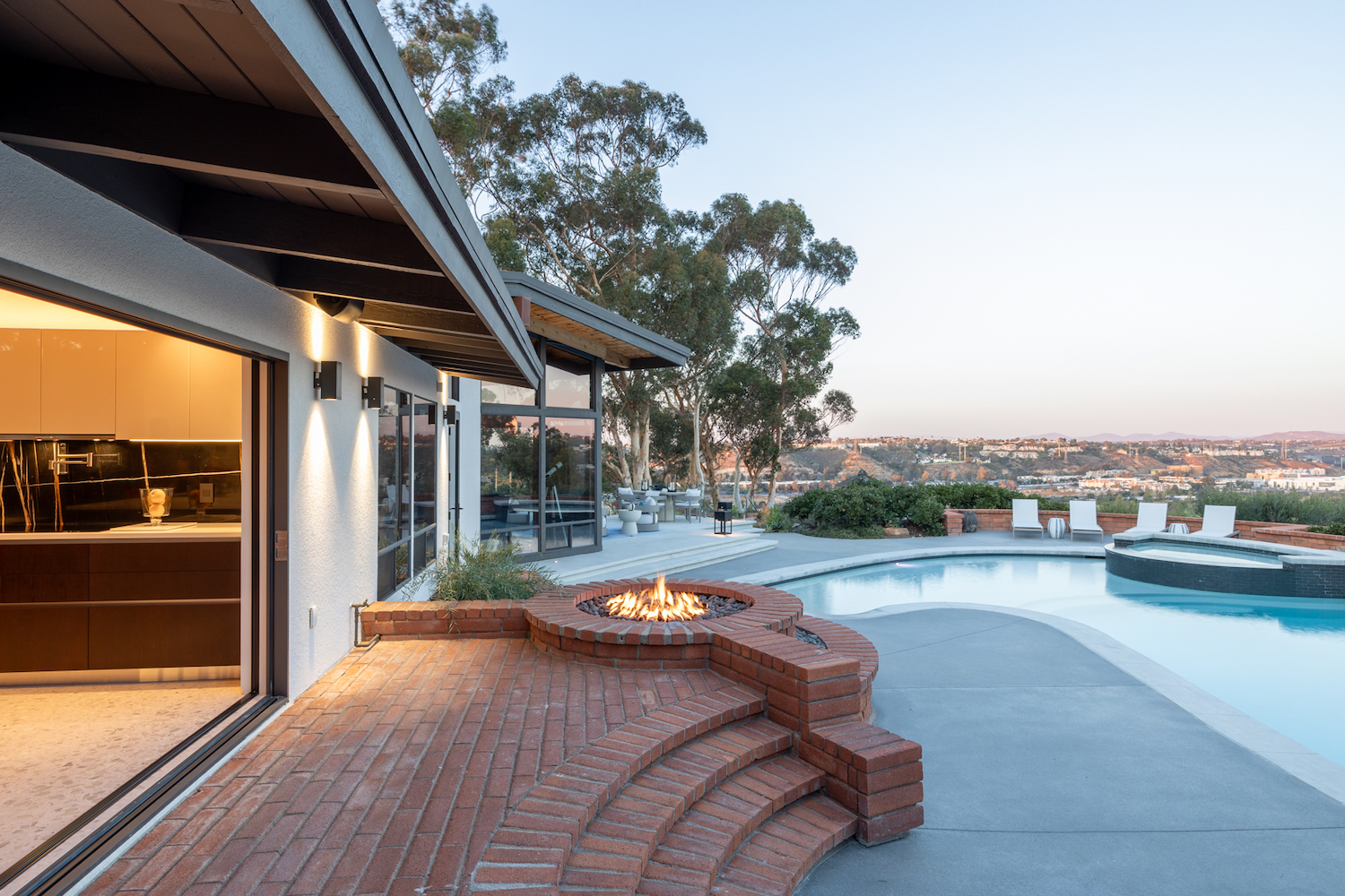 Exterior of midcentury craftsman home in Mission Hills, San Diego renovated by architects Taal Safdie and Ricardo Rabines featuring a pool, fireplace, and spa