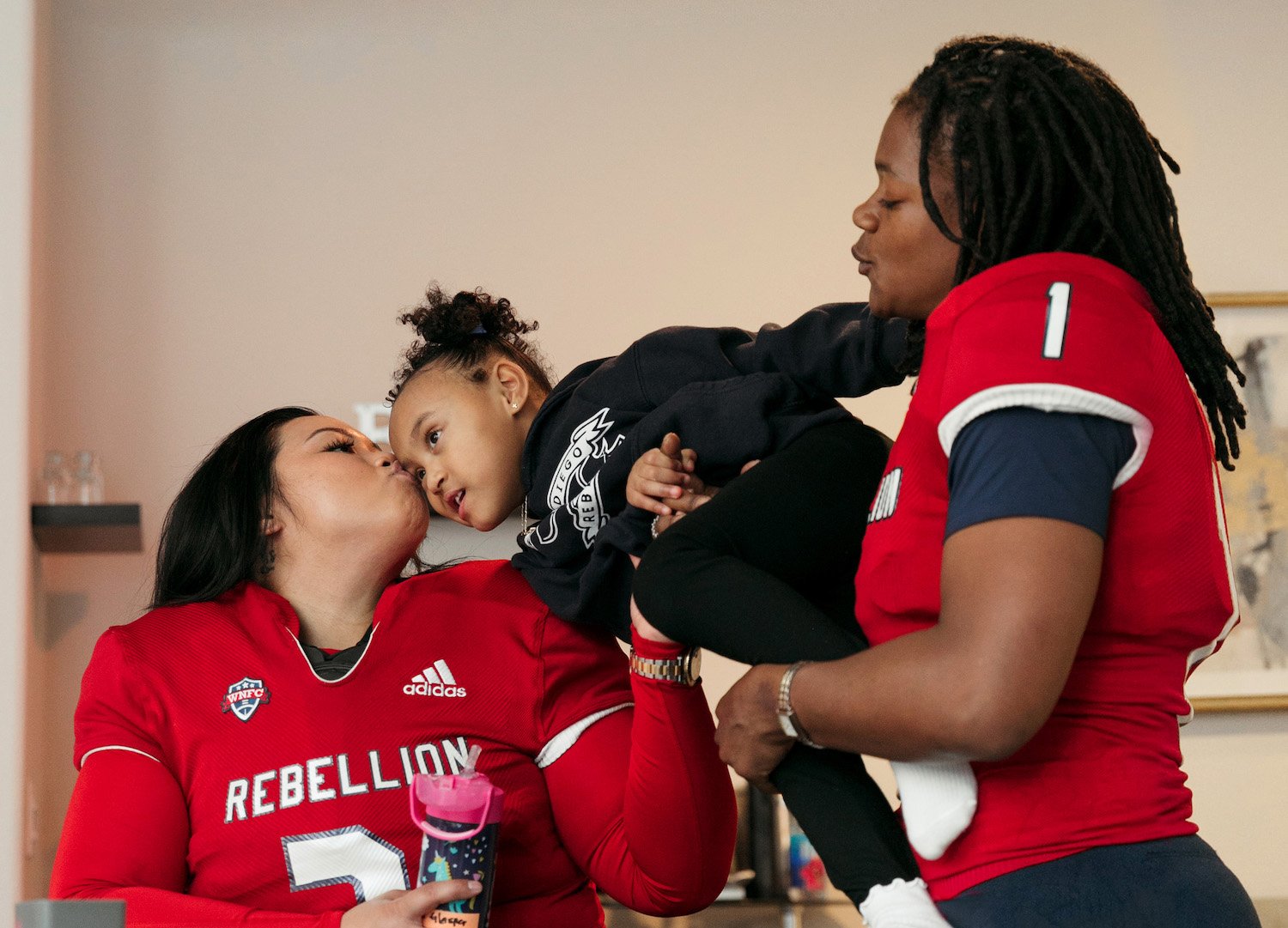 San Diego Rebellion women's football players Joann Mamuyac and Brittani Lusain with their kid