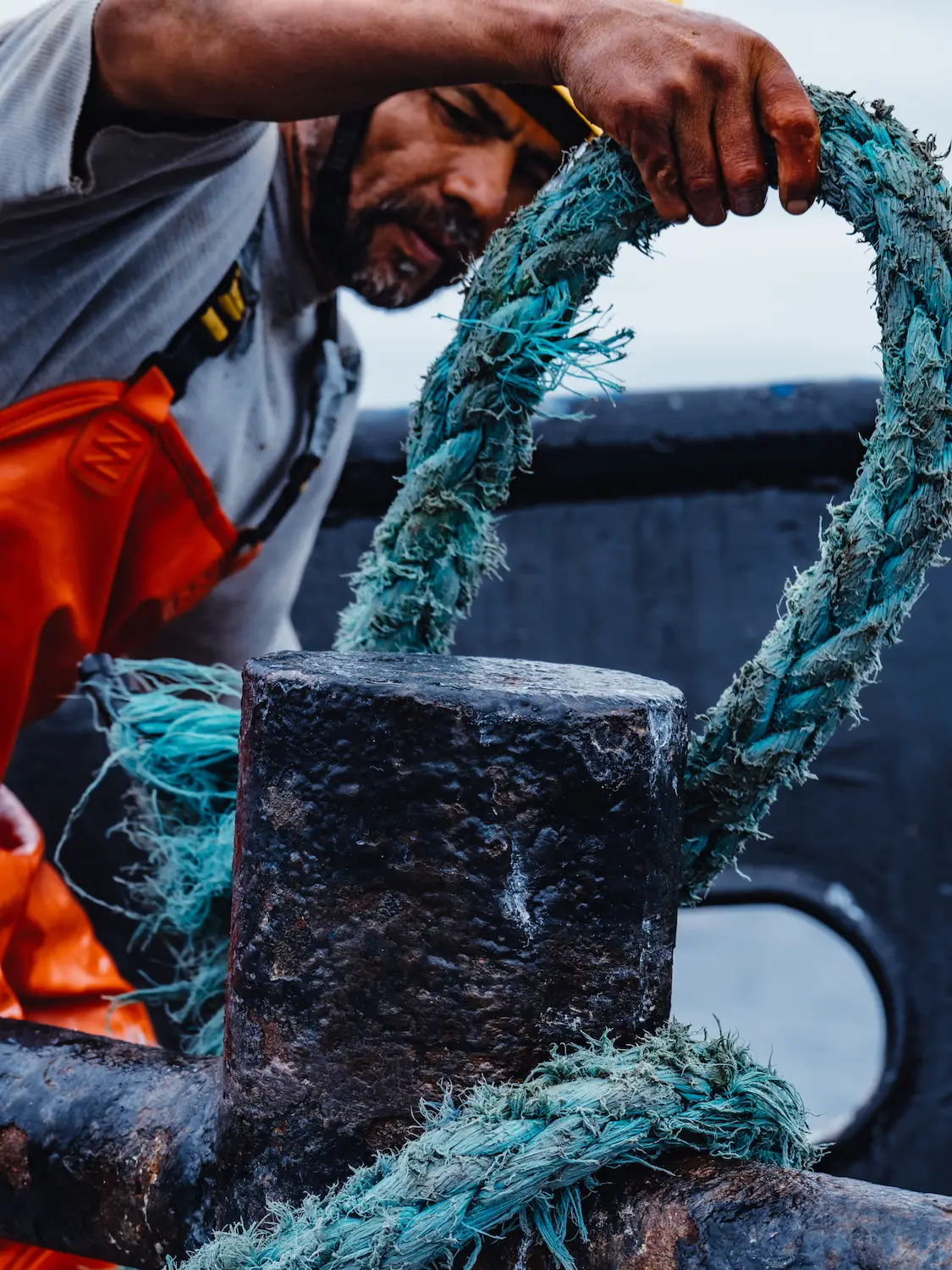 Baja Aqua Farm worker tying a knot on a fishing boat 