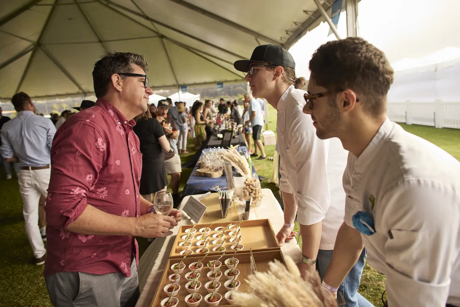 Food Network personality Troy Johnson talking with celebrity chefs at the 2025 Del Mar Wine + Food Festival VIP tent