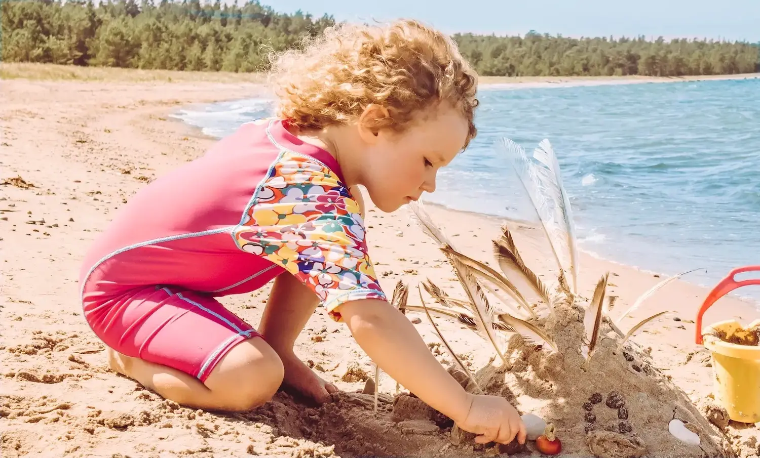 A child wearing a high ultraviolet protection factor (UPF) rash guard at the beach