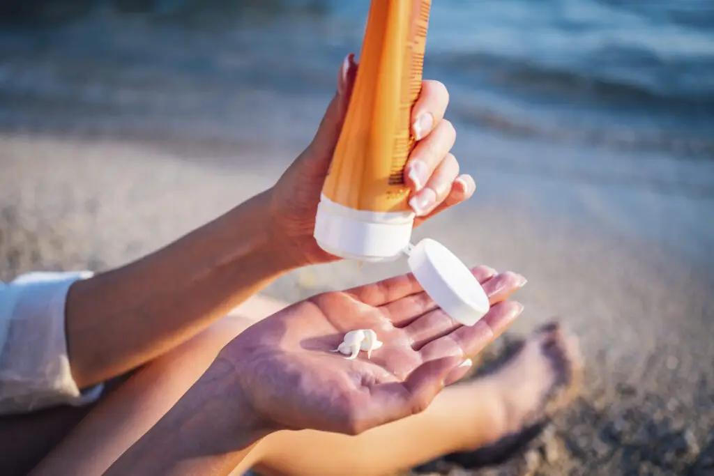 The best skincare routine for sun protection according to dermatologists featuring someone putting on sunscreen