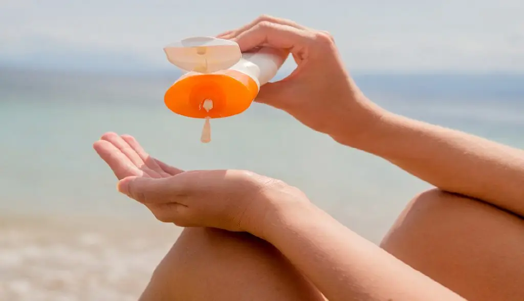 The best skincare routine for sun protection according to dermatologists featuring someone putting on sunscreen