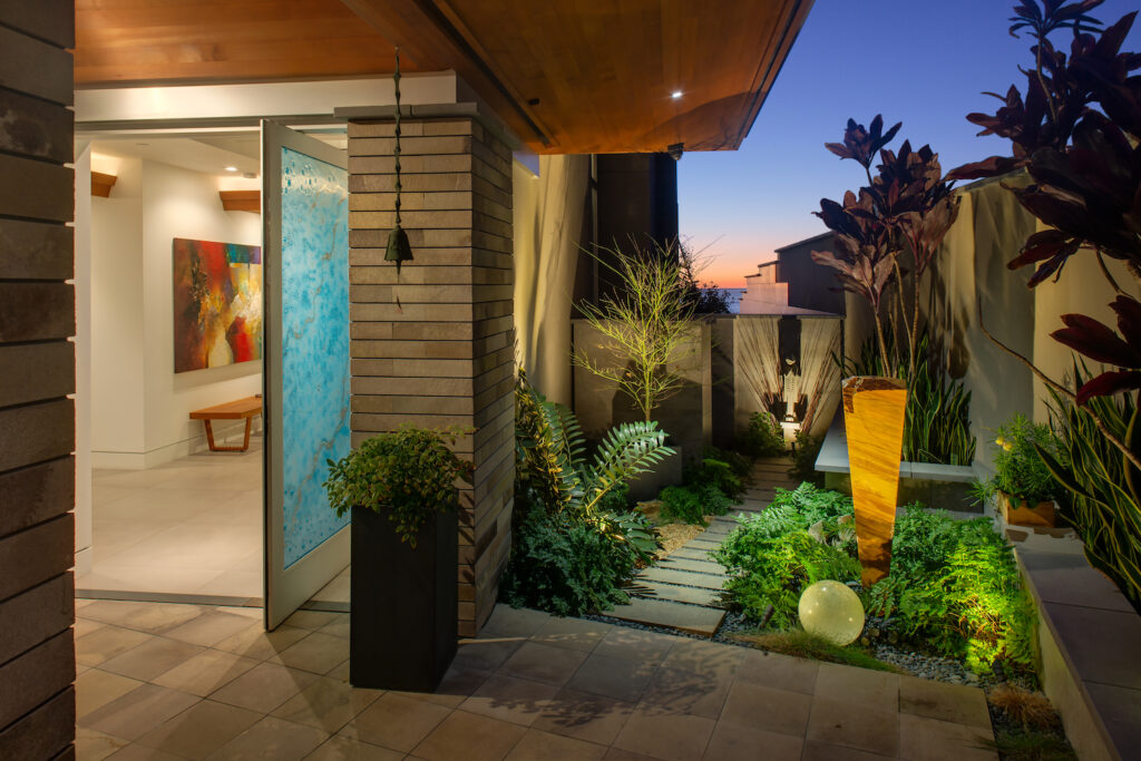 Exterior of San Diego architect Dean Meredith's Del Mar home featuring their front yard with a replica of Frank Lloyd Wright’s “sprites” concrete sculptures