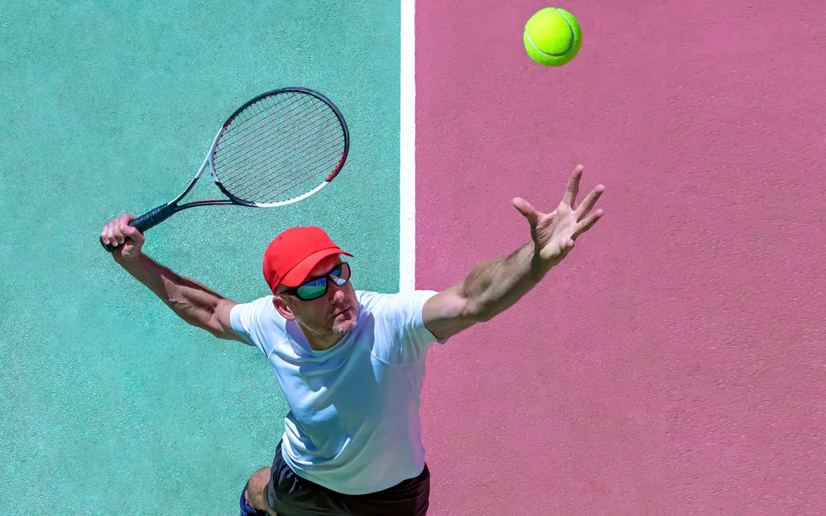 Tennis player serving on blue and pink court