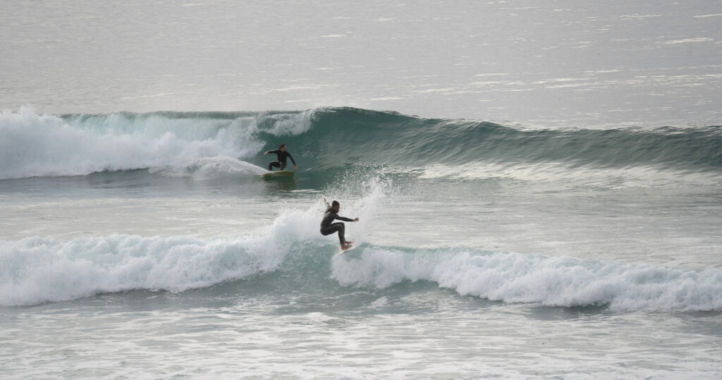 Surfers riding waves at Scripps Pier and La Jolla Shores
