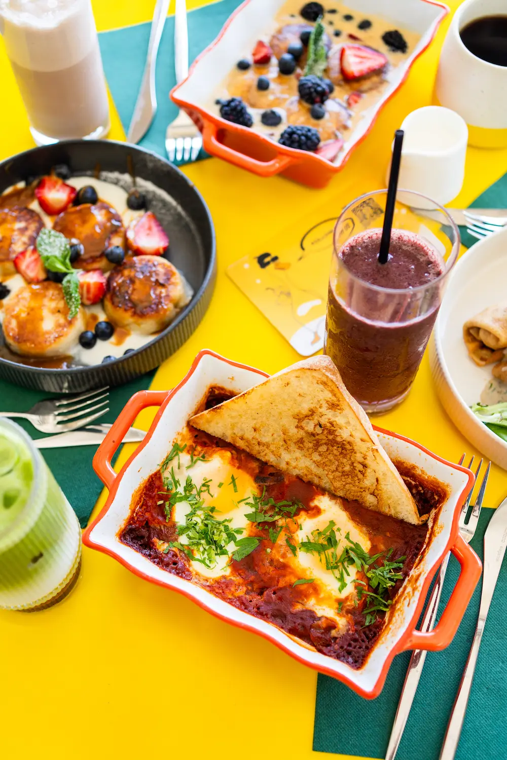Food from San Diego Ukrainian restaurant Need to Eat Cafe featuring includes shakshuka and syrniki, Ukranian cottage cheese pancakes.